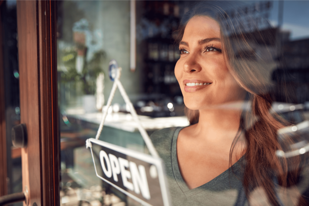 A girl puts up OPEN sign